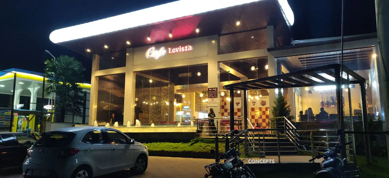 Café Levista at night, glass frontage and lit canopy, Kushalnagar